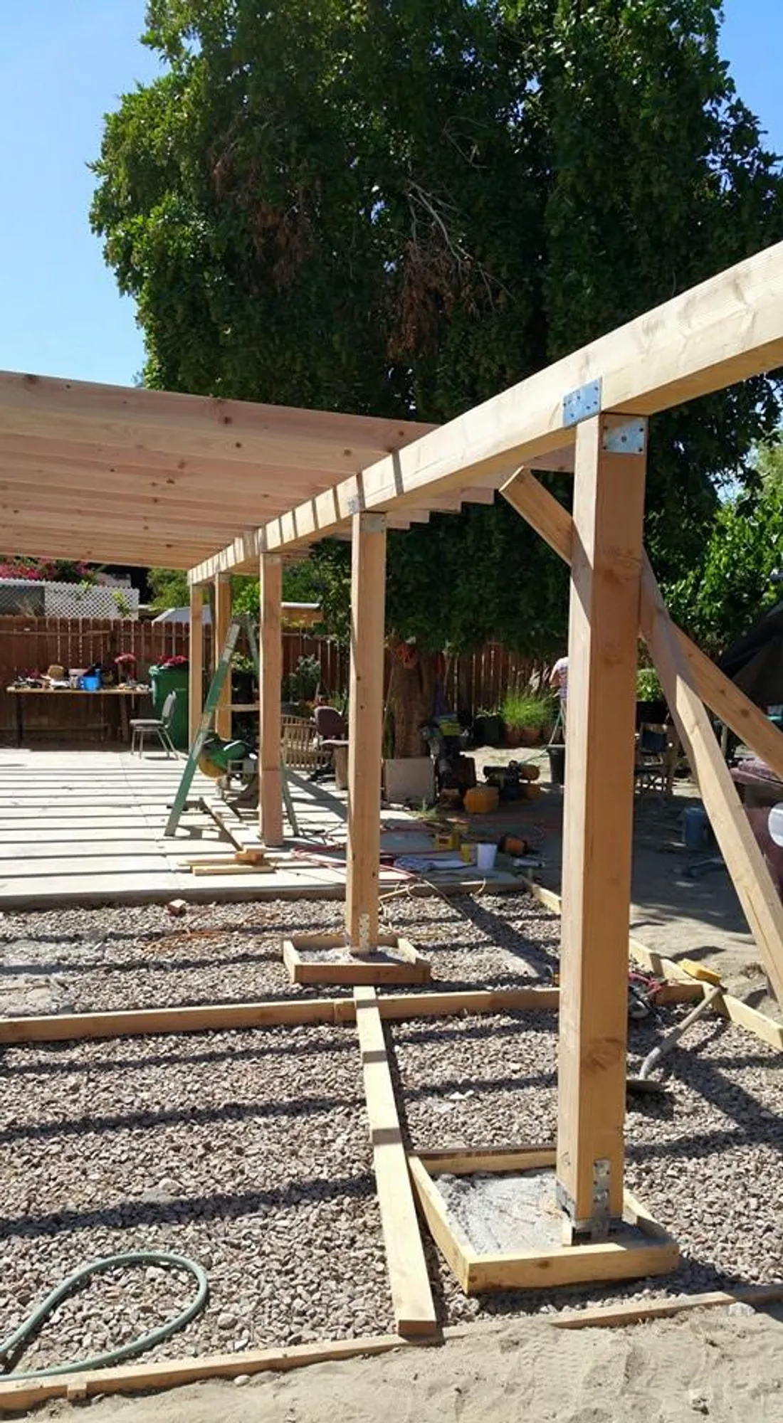 A patio cover under construction in an Upland backyard, rough lumber freshly cut and fastened.